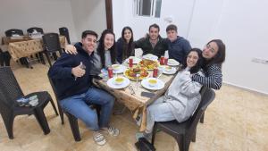 a group of people sitting around a table with food at Stay Classy Apartments in Wadi Musa