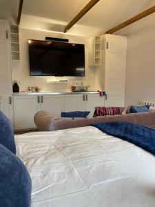 a living room with a couch and a flat screen tv at The Stable Yard @ Manor Bank Cottage in Beaulieu