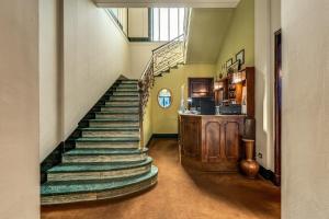 een trap in een huis met groene muren en een trap bij Hotel Apollo in Milaan