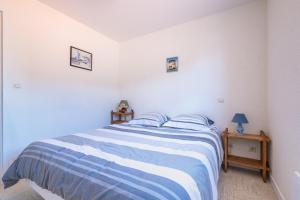 Schlafzimmer mit einem Bett mit blauer und weißer Bettwäsche in der Unterkunft L'Océanide - Vue mer pour 6 voyageurs in Saint-Michel-Chef-Chef