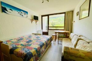 a bedroom with a bed and a couch and a table at Nice 28m Comfort In The Heart La Salle Les Alpes in La Salle Les Alpes