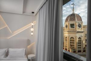 a bedroom with a window with a clock tower at Elisabeth Boutique Hotel in Thessaloniki +46 photos