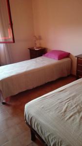 a bedroom with two beds and a pink pillow at appartamento a 700 mt. dal mare. in Terracina