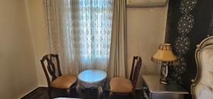 een kamer met een tafel en stoelen en een raam bij Altın Koza Hotel in Adana