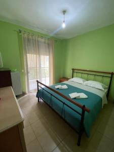 a bedroom with a large bed with green walls at Nea Skioni apartment in Nea Skioni