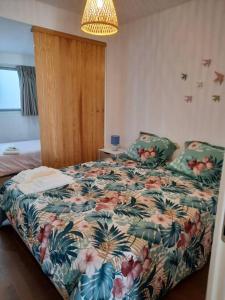 um quarto com uma cama com um edredão floral em Sado House 3 em Comporta