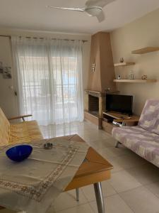 a living room with a couch and a table at Nea Skioni apartment in Nea Skioni