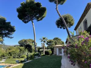 a house with palm trees and a yard at Magnifique Villa de prestige Antibes/Juan-les-Pins in Antibes