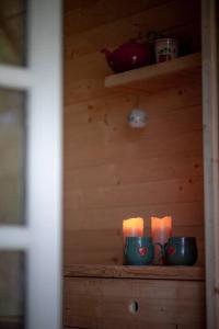 two candles on a shelf in a wooden room at Campingpod back to basic in Tønder