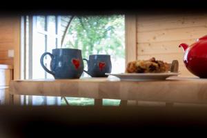 a table with two cups and a plate of food at Campingpod back to basic in Tønder