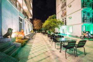 a row of tables and chairs in a courtyard at night at Beach House in Batumi