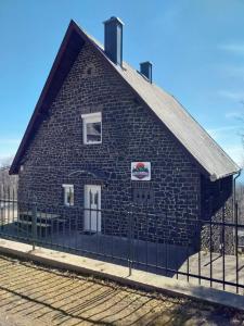 a blue brick building with a fence in front of it at Mátrai5Vendégház in Galyatető