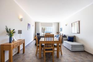 een woonkamer met een tafel en een bank bij CoolHouses Algarve Luz, 1 bed penthouse flat w/ sea views. Fiji 11 in Luz