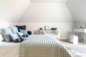 um quarto branco com uma cama grande e almofadas em Toppesfield Vineyard luxury, contemporary villa - 2 adults em Toppesfield