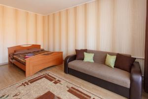 uma sala de estar com um sofá e uma cama em 1-комн. кв. в ЖК Дуэт em Kokshetau