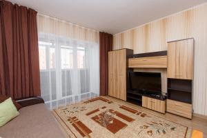 a living room with a television and a large window at 1-комн. кв. в ЖК Дуэт in Kokshetau