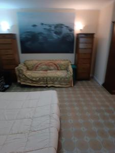 1 dormitorio con cama y sofá en Casa SoleMare a pochi passi dalla spiaggia di Terracina, en Terracina