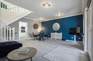 a living room with a blue wall and a table at Little Gleddoch in Dumbarton
