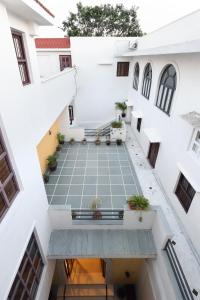 an empty courtyard in a white building with plants at The Cavalry - Abhay Niwas in Udaipur