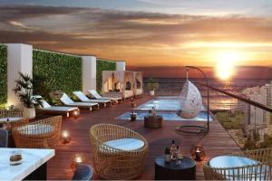 un patio en la azotea con mesas y sillas y una piscina en Lovely Aparment OceanView Barranco1809, en Lima