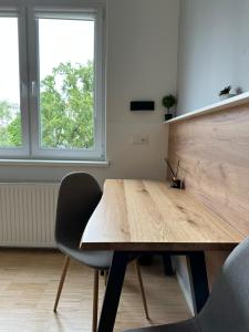 a wooden table and two chairs in a room with a window at Lion`s Rooms n Apartments in Vienna