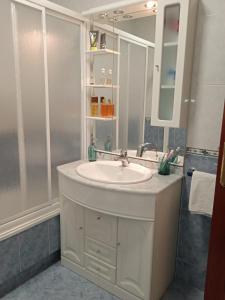 a bathroom with a white sink and a mirror at O Enxidro PLAYA, a 40 m de Playa Jardín in Boiro