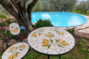 duas mesas com frutas pintadas ao lado de uma piscina em Poggio alla Pieve - Blu em Calenzano