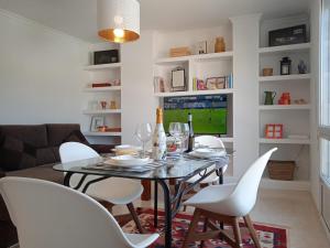 a dining room with a table and white chairs at O Enxidro PLAYA, a 40 m de Playa Jardín in Boiro