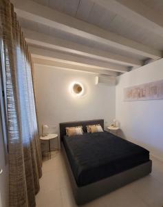 a bedroom with a black bed and two tables at Casa della Regina in Sirmione