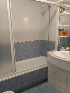 a bathroom with a shower and a tub and a sink at O Enxidro PLAYA, a 40 m de Playa Jardín in Boiro