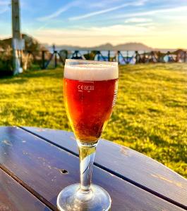 a glass of beer sitting on top of a wooden table at Alojamientos Rías Baixas - Mares del Forte- Cangas in Cangas de Morrazo