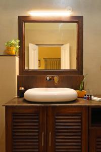 a bathroom sink with a large mirror above it at The Cavalry - Abhay Niwas in Udaipur