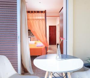 a room with a white table and a bedroom at Elena Studios and apartments in Nea Iraklia