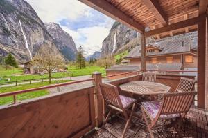 eine Veranda mit 2 Stühlen und einem Tisch mit Bergblick in der Unterkunft Apartment Mountain View, Luxury, Spacious with best Views in Lauterbrunnen