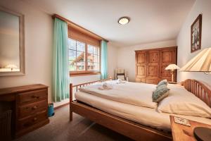 a bedroom with a bed and a desk and a window at Apartment Mountain View, Luxury, Spacious with best Views in Lauterbrunnen