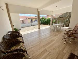 a living room with chairs and a wooden floor at Casa Tropicana in Flecheiras