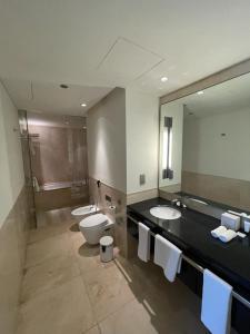 a bathroom with two sinks and a toilet and a mirror at The Address Dubai Marina in Dubai