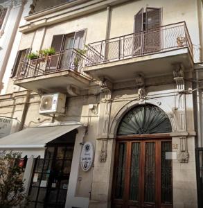 een gebouw met 2 balkons en een houten deur bij CASA LOSURIELLO in Triggiano