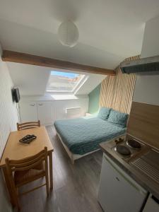 een kleine kamer met een bed en een tafel bij Une virée à Dunkerque entre ville et plage in Duinkerke