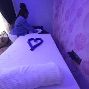 Una donna seduta su un letto con un cuore sopra di Kentania Hotel & Spa, Nakuru - Kenya a Nakuru