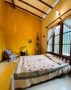 a bedroom with a large bed in a room with yellow walls at Pearl's Homestay Matale in Matale