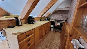 a small kitchen with wooden cabinets and a stove at Apartmány Anička vo Važci in Važec
