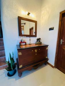 a bathroom with a dresser and a mirror on a wall at Pearl's Homestay Matale in Matale