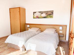 2 Betten in einem kleinen Zimmer mit in der Unterkunft Hôtel L'Hermitage in Saint-Georges-dʼOléron