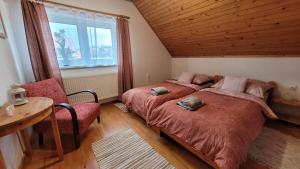 a bedroom with two beds and a table and a chair at Apartmány Anička vo Važci in Važec