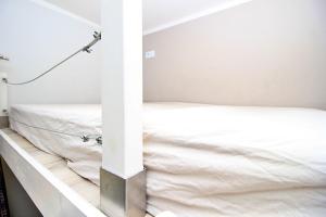 białe łóżko w pokoju z ainylinylinylinylinylowym w obiekcie Apartamenty Jozefa Kazimierz w Krakowie