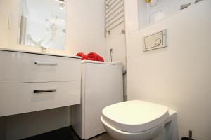 biała łazienka z toaletą i oknem w obiekcie Apartamenty Jozefa Kazimierz w Krakowie