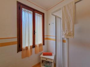 Una habitación con dos ventanas y una mesa pequeña. en Villa Mirella Trilocale, en Capoliveri