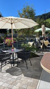 a table and chairs with an umbrella on a patio at Hotel Victoria - adults only in Gerlos