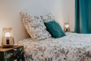 - une chambre avec un lit avec des oreillers et 2 lampes dans l'établissement JUPITER - Un logement neuf et de qualité, à Saint-Étienne